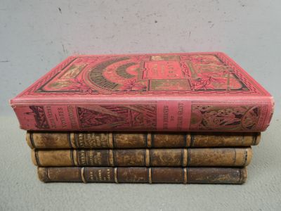 trois vieux livres empilés les uns sur les autres sur une table