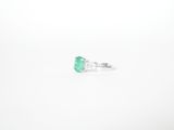 an emerald and diamond ring on a white background