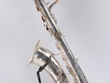 an image of a silver saxophone sitting on top of a black stand