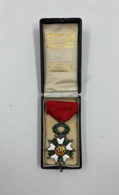une petite médaille dans un écrin noir, accompagnée d'un ruban rouge