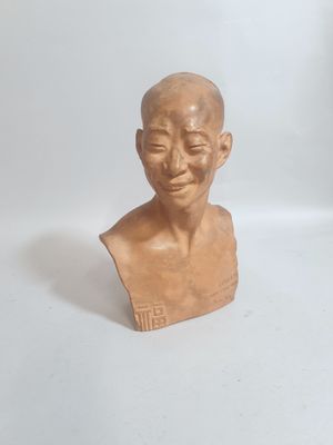 une petite statue représentant un homme assis sur une table