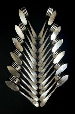 many forks and spoons arranged together on a black surface