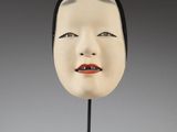 head of a woman with black hair and red lips on a black stand
