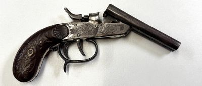un pistolet posé sur une surface blanche