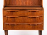 a close up of a wooden dresser with a shelf on top