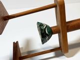 a wooden object with a green stone on top of it