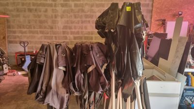 many pairs of pants hanging on a rack in a garage