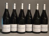 six bouteilles de vin sont alignées sur une table
