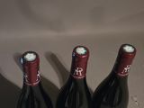 three bottles of wine sitting on top of a table next to each other