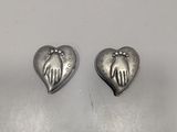 a pair of silver heart shaped earrings with hands on them