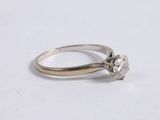 a close up of a diamond ring on a white surface
