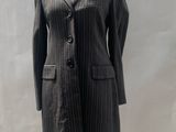 grey pinstripe suit on a mannequin stand in front of a white backdrop