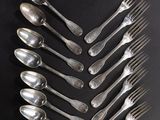 un grand nombre de cuillères et de fourchettes disposées sur une table