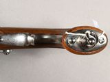 an old gun with a wooden handle on a white surface