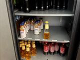 a small refrigerator filled with bottles of soda and other beverages