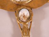a gold clock with a picture of a building on it