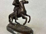 bronze statue of a man on a horse on a marble base