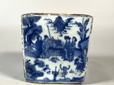 un vase bleu et blanc orné d'une image représentant des personnes