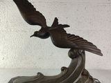 statue of a bird on a marble base on a white background