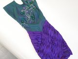 purple and green dress on a white surface