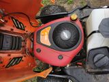 a red and black lawn mower sitting on the ground