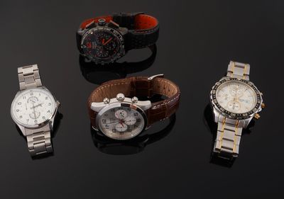 several different watches on a black surface with a black background