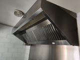 une hotte en acier inoxydable au milieu d'une cuisine