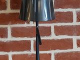 une lampe posée sur une table devant un mur de briques