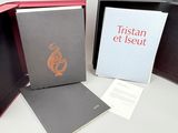 trois livres dans une boîte, posés les uns à côté des autres sur une table