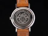 a close up of a watch with a leather strap on a black background