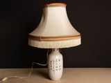 a lamp that is sitting on a table with a lamp shade on it