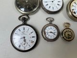 several different types of pocket watches are displayed on a white surface