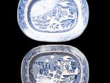 two blue and white plates with designs on them on a black surface