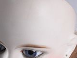 a close up of a doll ' s head with blue eyes