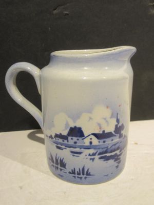 a white pitcher with a blue and white design on it
