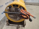 a yellow blower sitting next to a wall with a bunch of hoses attached to it