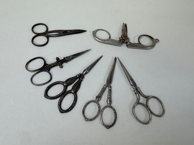 several pairs of scissors are arranged in a circle on a white surface