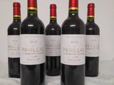 four bottles of red wine are lined up on a table