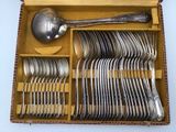 a lot of silverware in a box with a spoon and spoon rest