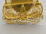 une broche en or sur laquelle est fixée une pièce de monnaie
