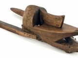 an old wooden clamp with a piece of wood sticking out of it