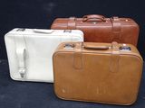 three suitcases sitting next to each other on a black surface