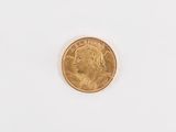 a close up of a gold coin on a white surface