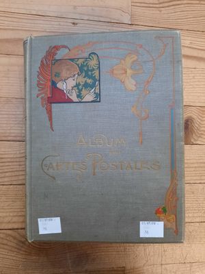 un vieux livre posé sur une table en bois, avec l'image d'un oiseau