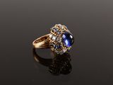an oval sapphire and diamond ring on a black surface