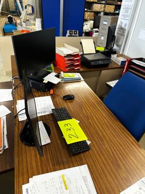 un bureau sur lequel se trouvent un ordinateur, un clavier, une souris et des papiers