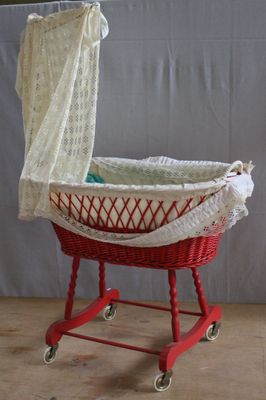 a red basket with a white blanket on top of it
