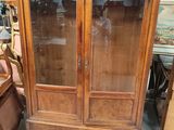 une armoire en bois avec une porte vitrée et une chaise