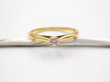 une bague de fiançailles en or ornée d'un diamant posé sur une branche