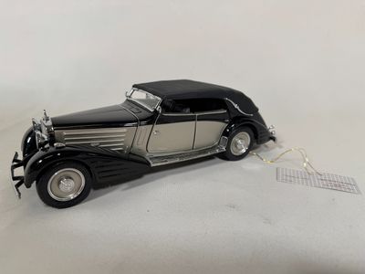 a black and silver model of a car on a white surface
